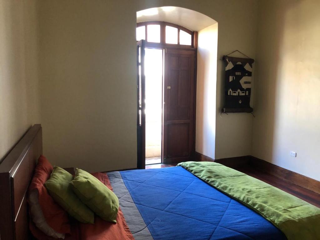 a bedroom with a bed with a blue comforter at HOSPEDAJE las PRIMICIAS 103 in Riobamba