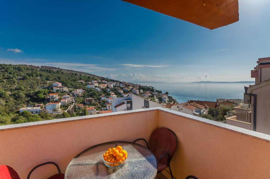 a table on a balcony with a bowl of oranges at Apartments Vlado in Trogir