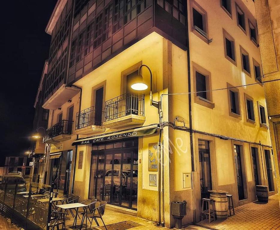 a building with tables and chairs outside of it at Apartamentos Casa Rosendo in Cangas del Narcea