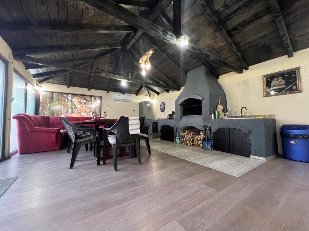 sala de estar con mesa y chimenea en Casa Lupilor Transfăgărășan en Căpăţîneni-Ungureni