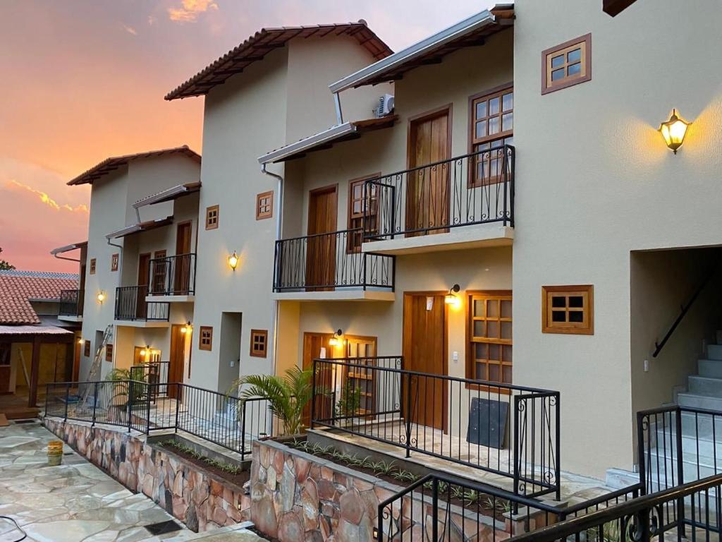 a building with balconies and a sunset in the background at Pousada Mãe Natureza in Pirenópolis