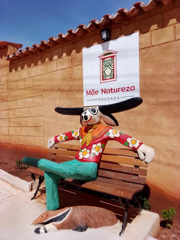 a statue of a dog sitting on a bench at Pousada Mãe Natureza in Pirenópolis
