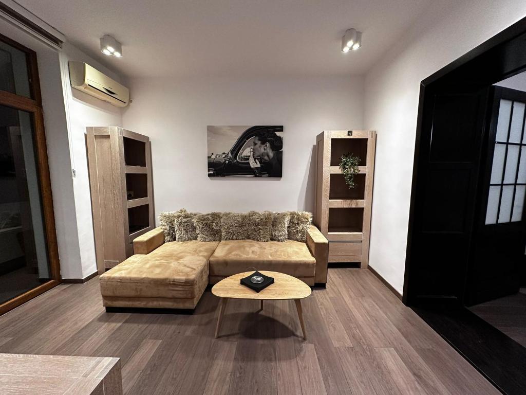 uma sala de estar com um sofá e uma mesa em elisio - Pani Nani Apartment em Brasov