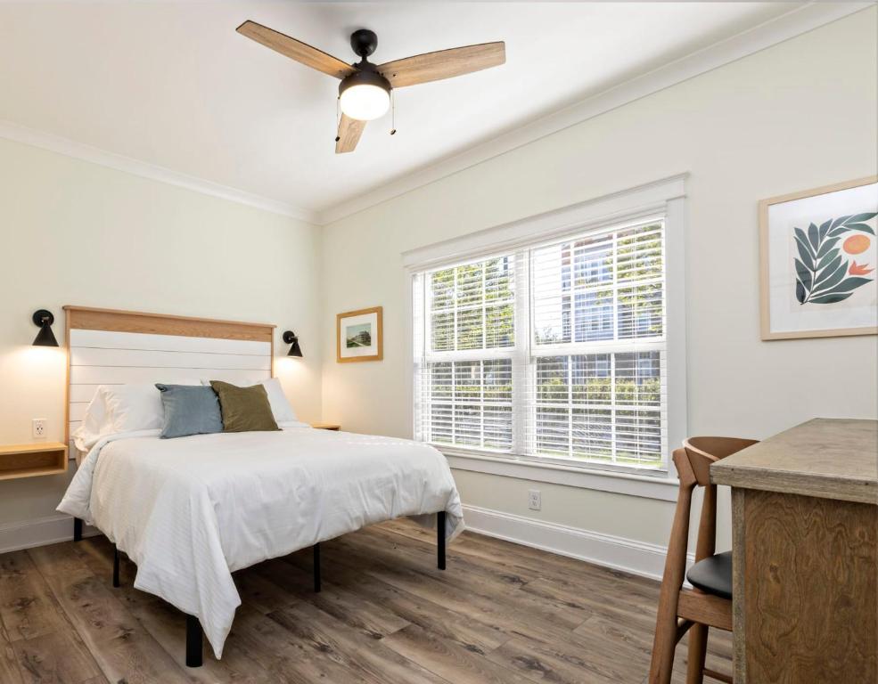 a white bedroom with a bed and a ceiling fan at The Waverly 100 Inn at Old Beach in Virginia Beach