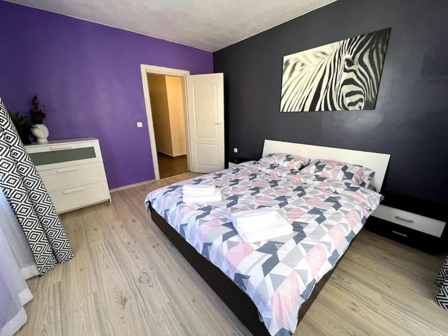 una camera con letto e parete viola di Lovely 2-bedroom rental unit in Sofia a Sofia