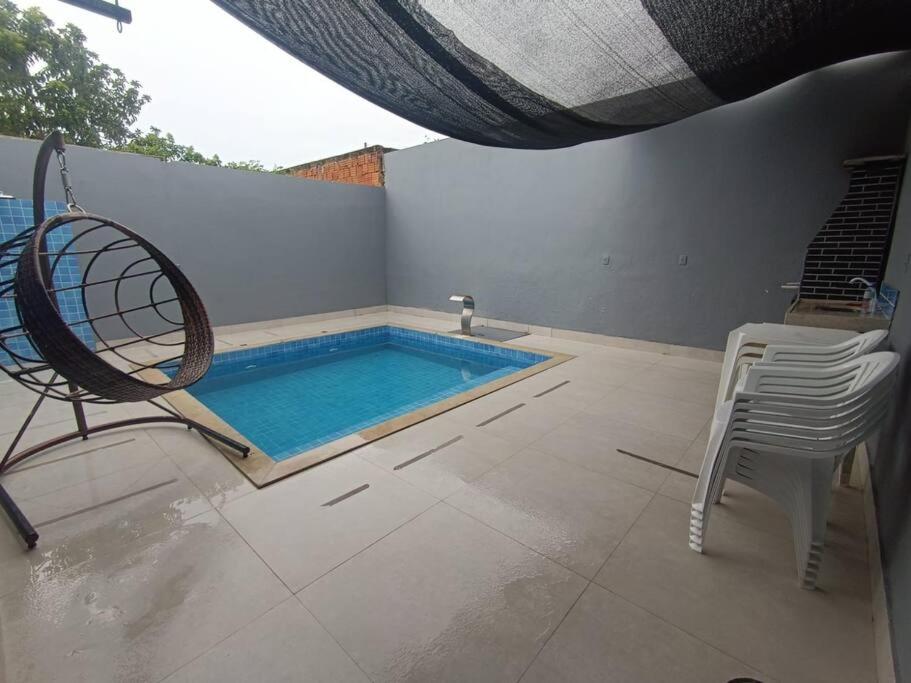 a swimming pool with a chair and a table at House 91 in Montes Claros