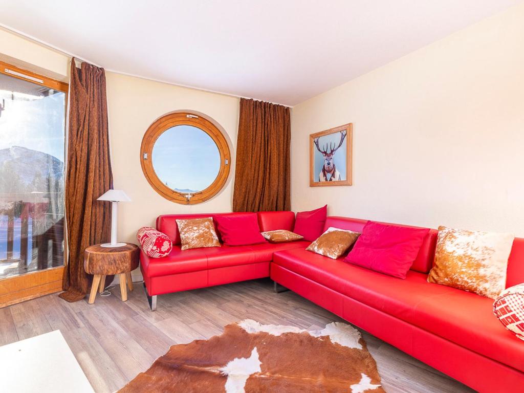 a red couch in a living room with a window at Appartement Avoriaz, 2 pièces, 6 personnes - FR-1-314-254 in Morzine