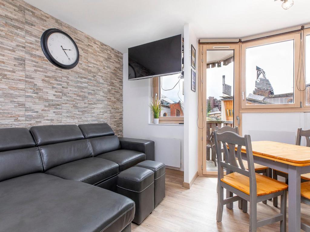 a living room with a couch and a table and a clock at Studio Avoriaz, 1 pièce, 4 personnes - FR-1-314-272 in Morzine