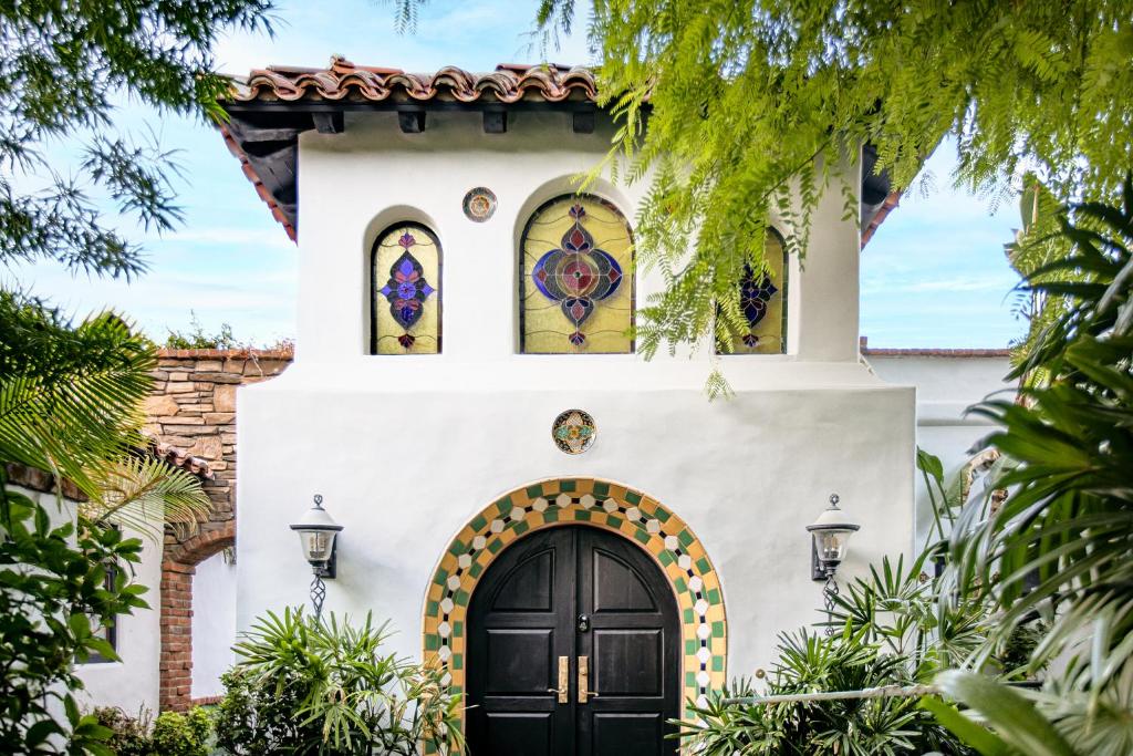 une maison avec une porte noire et des vitraux dans l'établissement Lucille Palm Springs, à Palm Springs