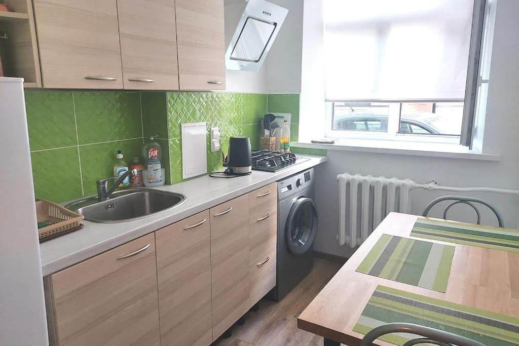 a kitchen with a sink and a washing machine at Comfy apartment with 2 bedrooms in Rīga
