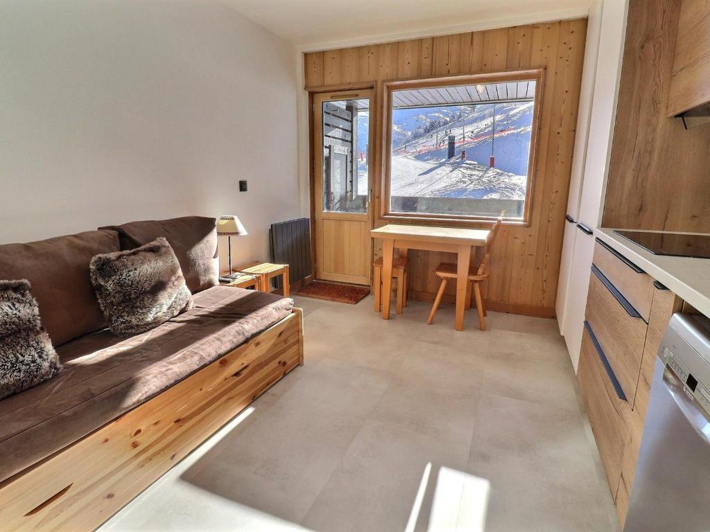 un salon avec un canapé et une fenêtre dans l'établissement Studio rénové au pied des pistes, exposé sud avec balcon et Wi-Fi, proche commerces et ESF - FR-1-182-167, à Méribel