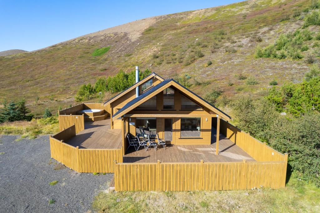 una casa con una gran terraza en una colina en Beautiful cabin near Grenivík en Grenivík