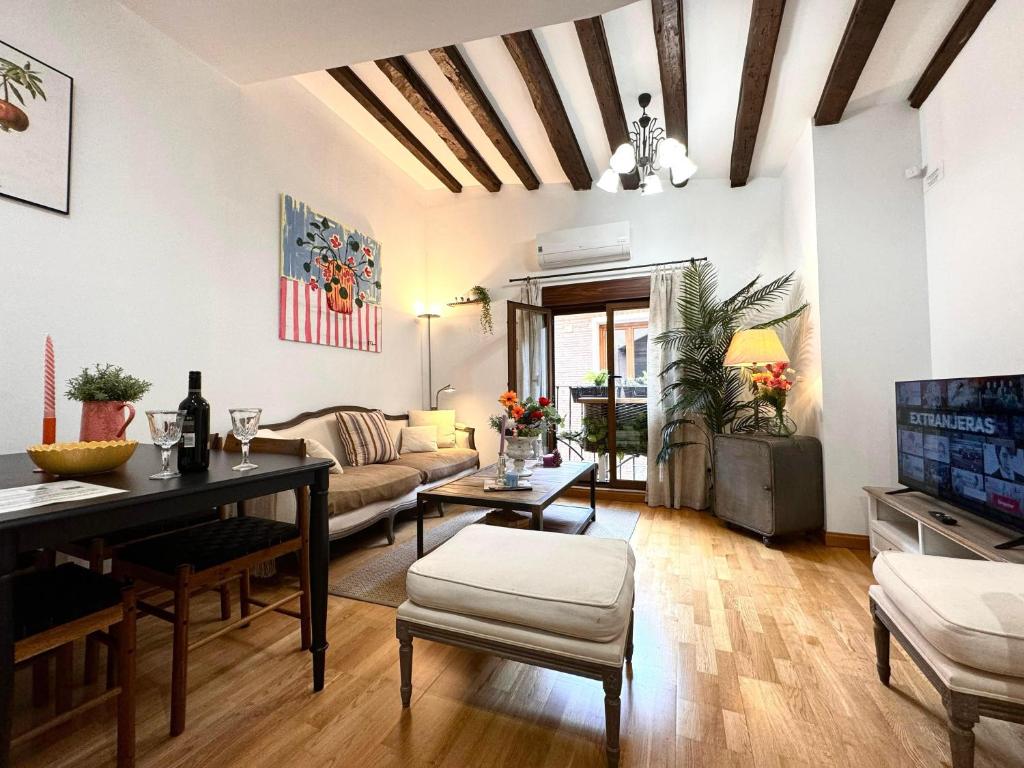 ein Wohnzimmer mit einem Sofa und einem Tisch in der Unterkunft Suite Imperial II * Historic Center * Early Check-in in Toledo