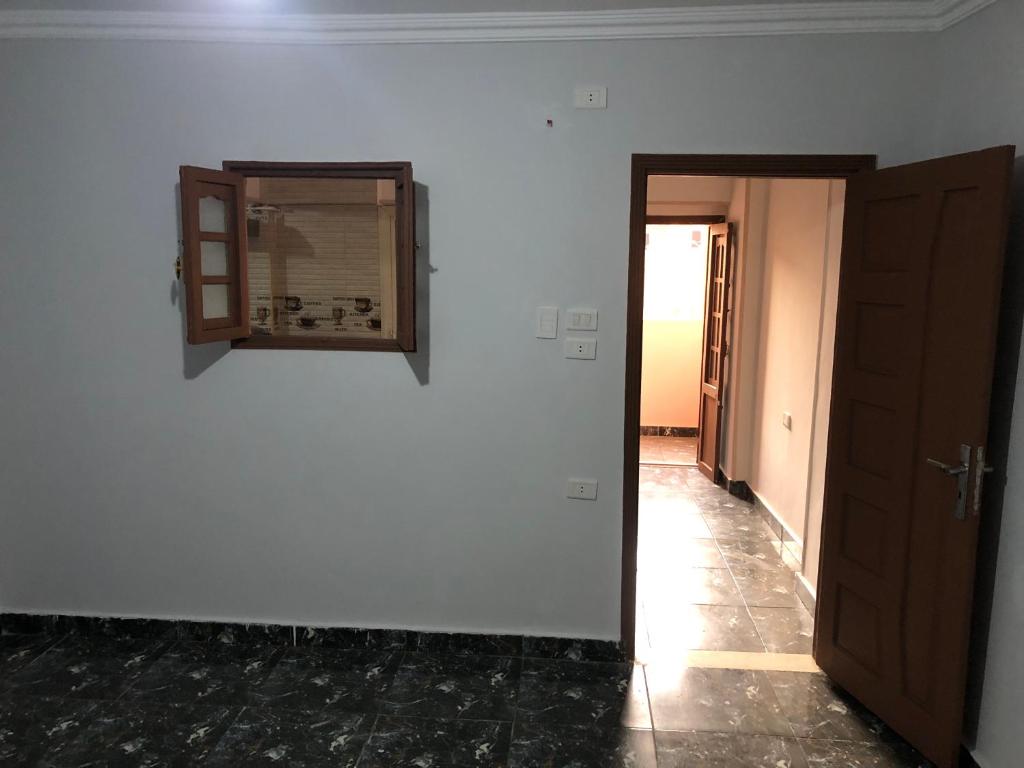 una camera con una parete bianca, uno specchio e una porta di شارع على سلامة متفرع من يوسف ابو طالب - الحرفيين - السلام a Il Cairo