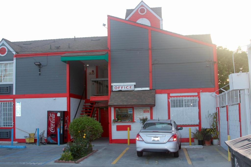 une voiture garée dans un parking en face d'un magasin dans l'établissement The Broadway Inn, à Los Angeles