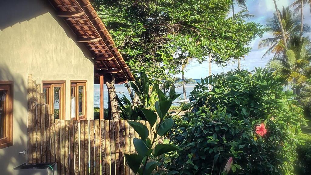 een huis met een hek en wat planten en bomen bij Casa Hibiscus in Ilha de Boipeba
