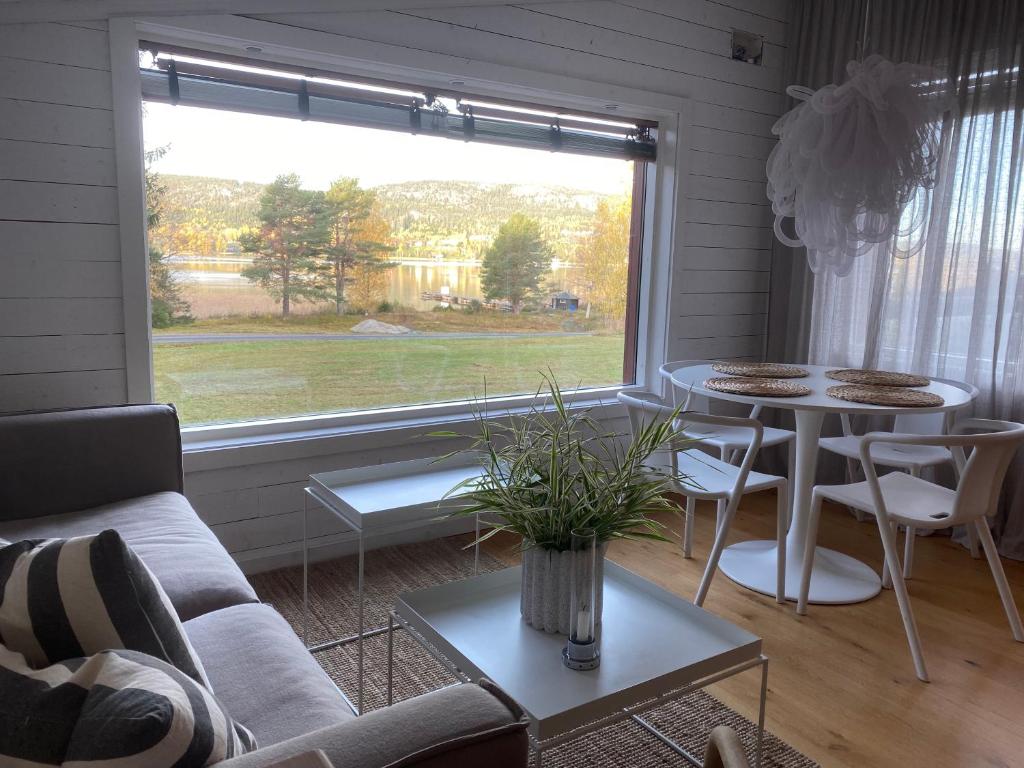 uma sala de estar com um sofá, uma mesa e uma janela em Peaceful and Scandinavian-style Guesthouse with Scenic Nature and Seaview in High Coast em Domsjö