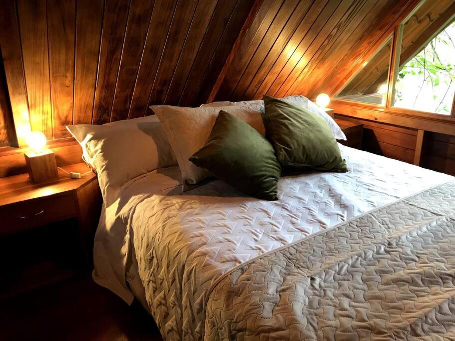 a bedroom with a bed with pillows and a window at Casa del árbol - laVerde HABITAT 