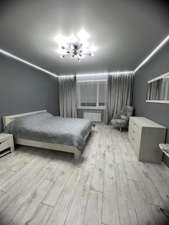 1 dormitorio con 1 cama y ventilador de techo en Квартира - студия 72 кв.м, en Uralsk