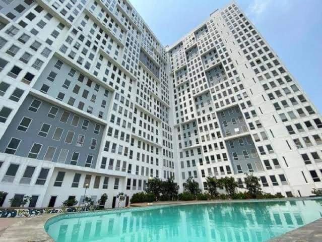 two tall white buildings with a pool in front at R2R Room in Bulanbulan