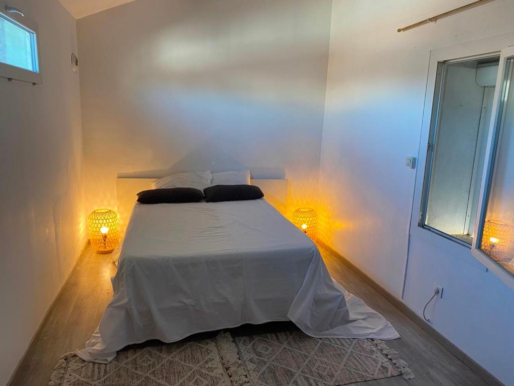 a bedroom with a white bed with two pillows on it at Duplex 5, Rue Sainte Catherine in Nîmes