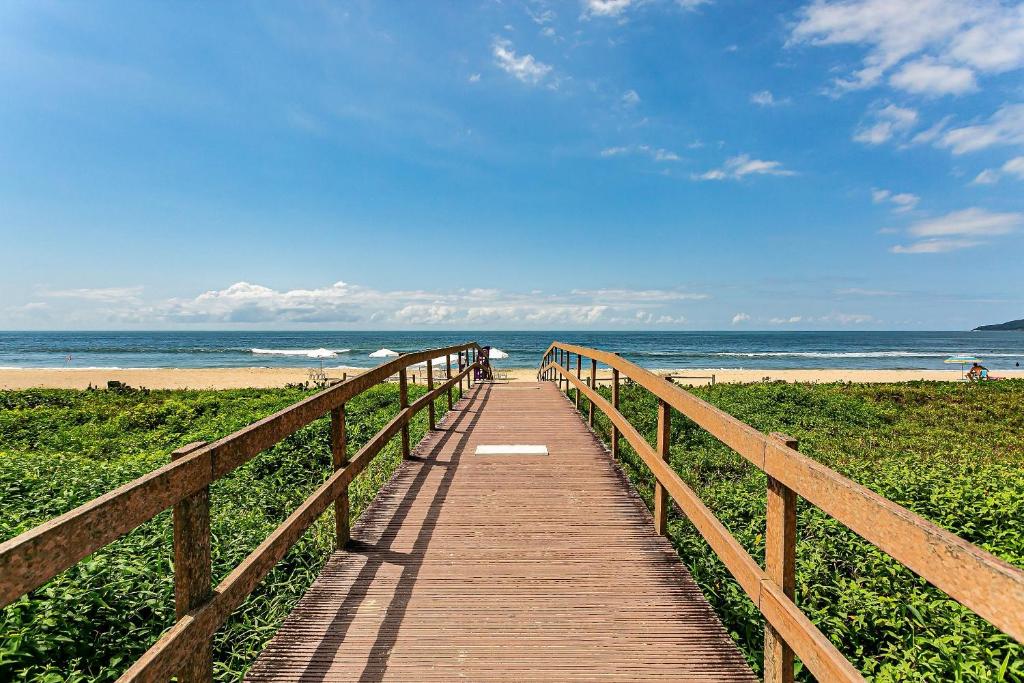 een houten promenade die naar het strand leidt bij Belo apto com varanda a 150m do mar ABC202 in Itajaí
