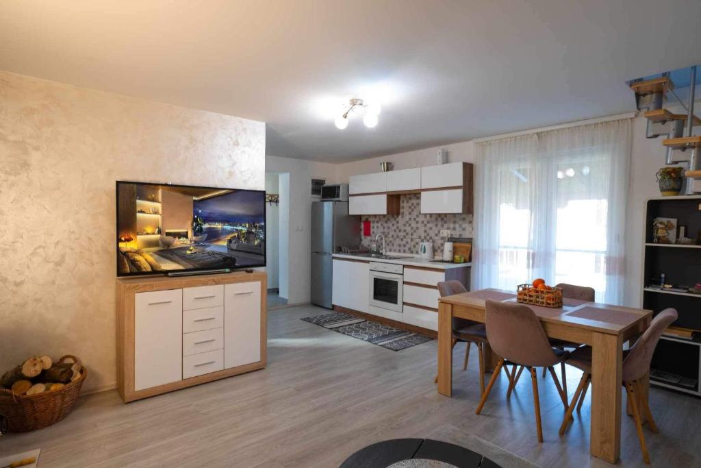 uma cozinha e sala de jantar com uma mesa e uma televisão em Kuća za odmor PAVIĆ em Vinkovci