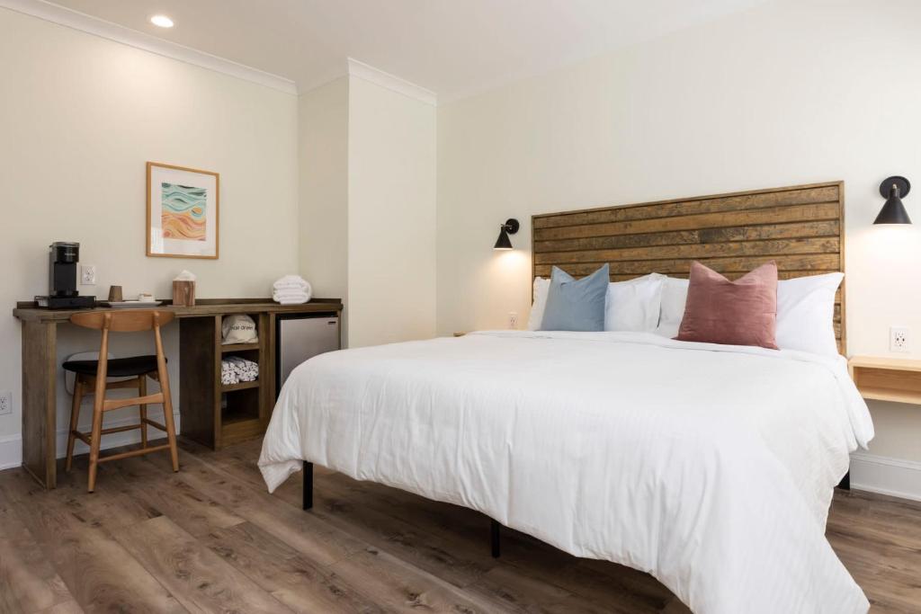 1 dormitorio con 1 cama grande y escritorio en Pinewood 102 Inn At Old Beach en Virginia Beach