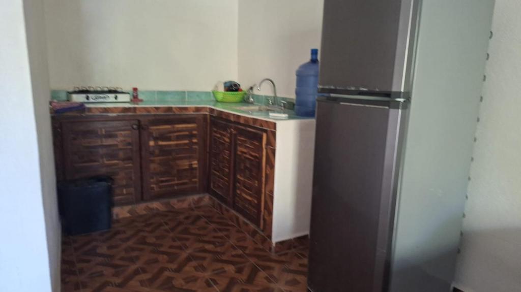 a kitchen with wooden cabinets and a refrigerator at Chuchosmom room 3 in Temalhuacán