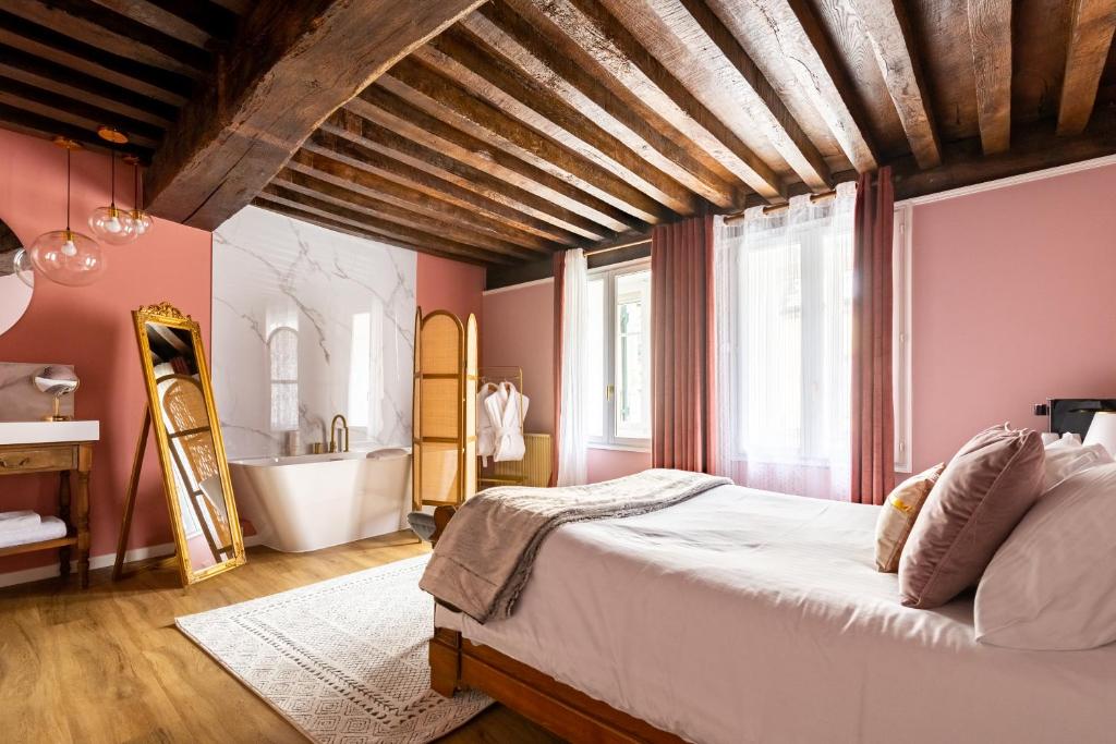 アルネ・ル・デュックにあるChez Camilleのベッドルーム(大型ベッド1台、バスタブ付)