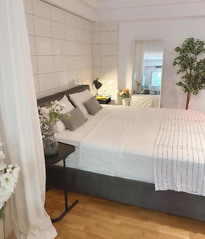 a bedroom with a large white bed and a bathroom at Stylish & Cozy Studio in Igoumenitsa