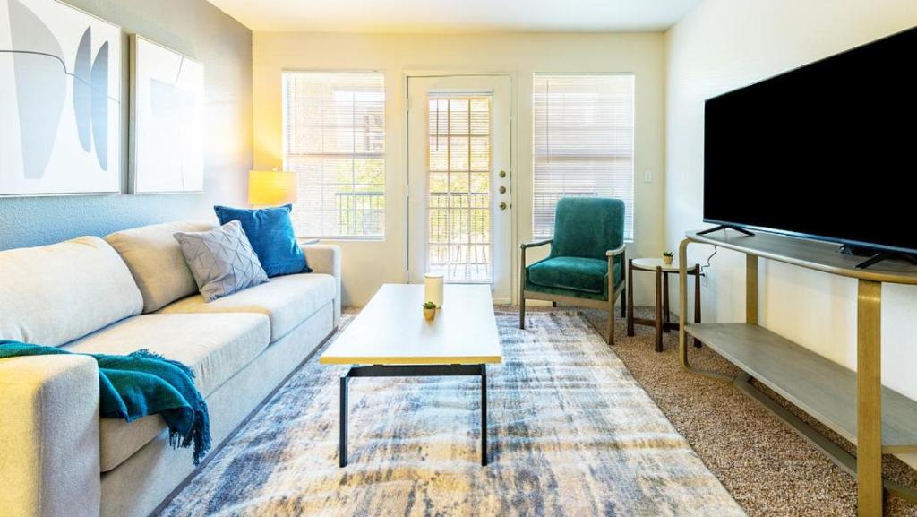 sala de estar con sofá y TV de pantalla plana en Landing Modern Apartment with Amazing Amenities (ID6628X19), en Albuquerque