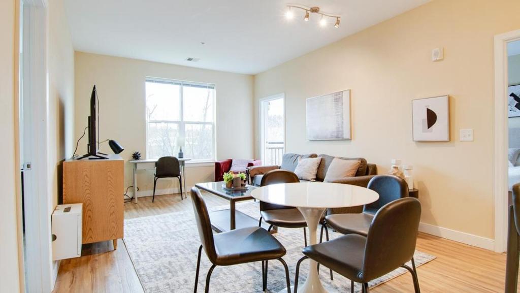 Landing Modern Apartment with Amazing Amenities (ID7221X88) في فريدريك: غرفة معيشة مع طاولة وأريكة