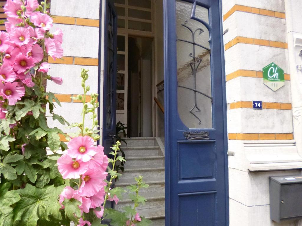 a blue door on a house with pink flowers at B&B Matin Tranquille in Liège