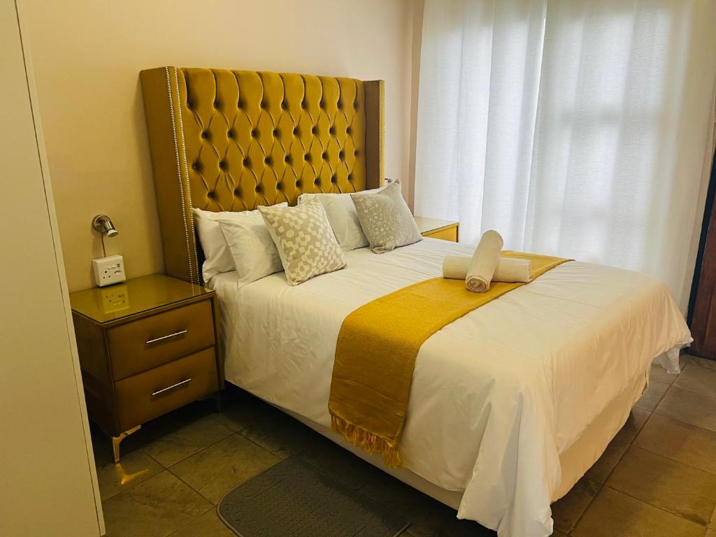 ein Schlafzimmer mit einem großen Bett mit einem großen Kopfteil in der Unterkunft Winbert Apartments in Ladysmith
