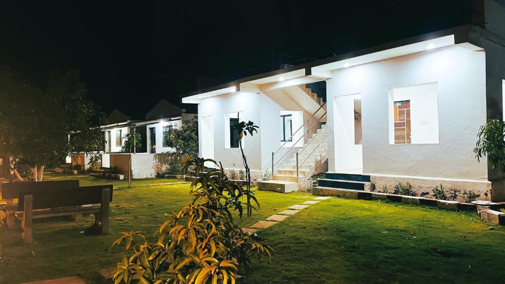 ein Haus mit einer Bank in der Nacht davor in der Unterkunft AamraKunj Gir Resort in Sasan Gir