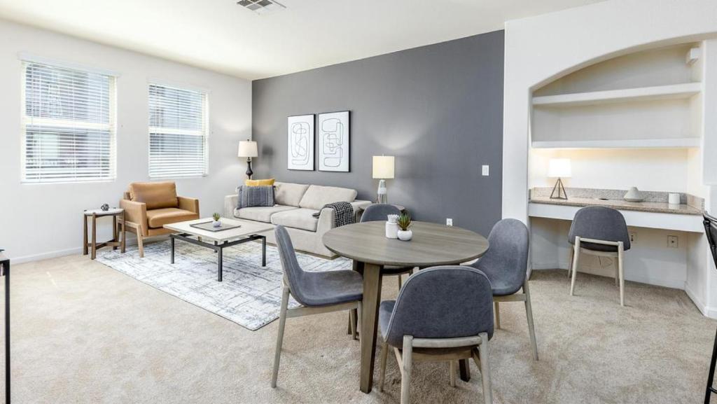 uma sala de estar com um sofá, uma mesa e cadeiras em Landing Modern Apartment with Amazing Amenities (ID5499X01) em San Diego