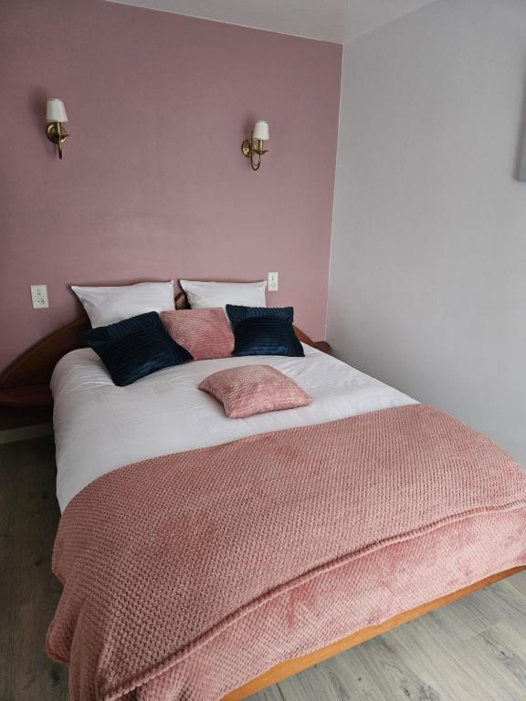 - une chambre avec un grand lit aux murs roses dans l'établissement Maison la vigne haute, à Saint-Viance