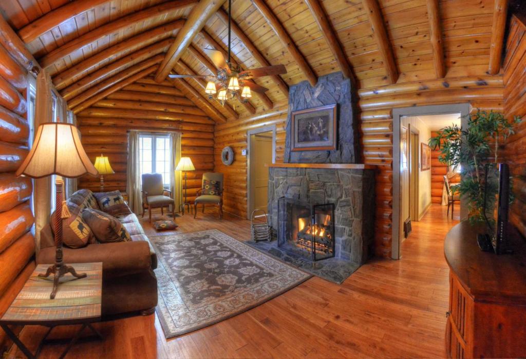 uma sala de estar com lareira num chalé de madeira em Historic Log Cabin #14 at Horse Creek Resort em Rapid City