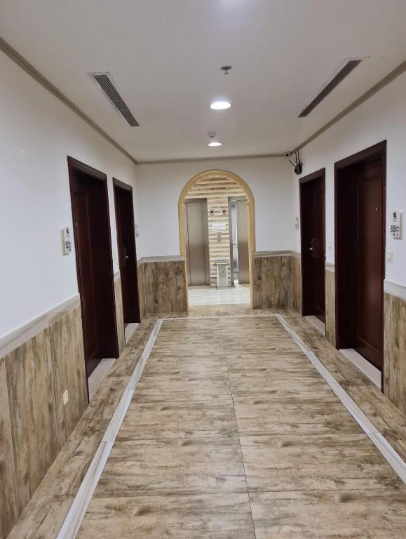 einen leeren Flur in einem Gebäude mit Holzböden in der Unterkunft فندق العنقود - قريش in Dschidda