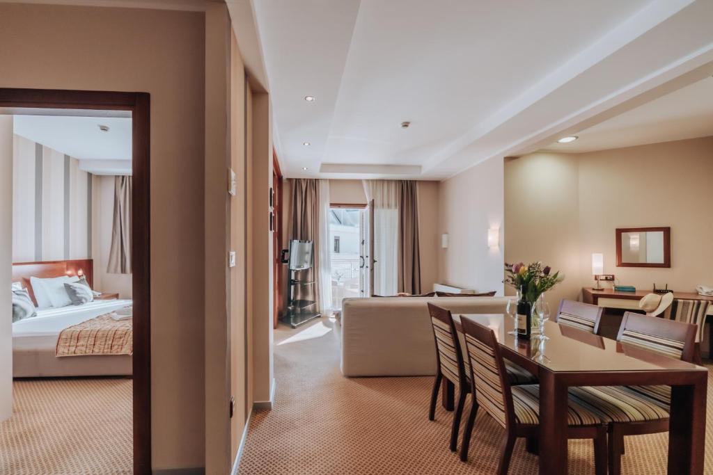 a hotel room with a bed and a table and chairs at Apartments Del Mar in Petrovac na Moru