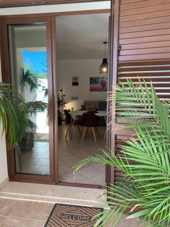 uma porta de vidro deslizante que dá acesso a uma sala de estar com uma mesa em Kite Village Solaris em Birgi Vecchi
