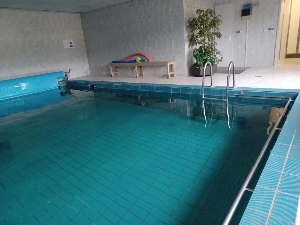 a swimming pool with a bench in the middle of it at Haus Lucia, mit Pool und Sauna, Appartment 4 in Schonwald im Schwarzwald
