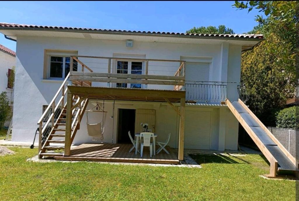 ein Haus mit einer Terrasse und einem Tisch davor in der Unterkunft Charmant T2 avec terrasse jardin et parking privé, à 2 minutes du centre ville ! in Villeneuve-sur-Lot