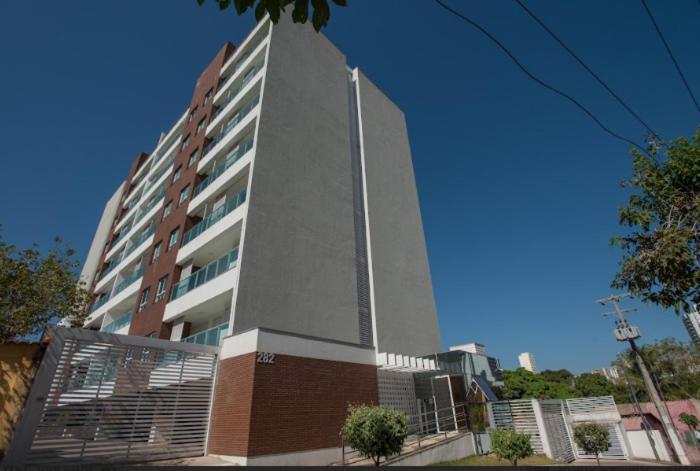 a tall building in front of a building at Starlis Home - Versátil in Cuiabá