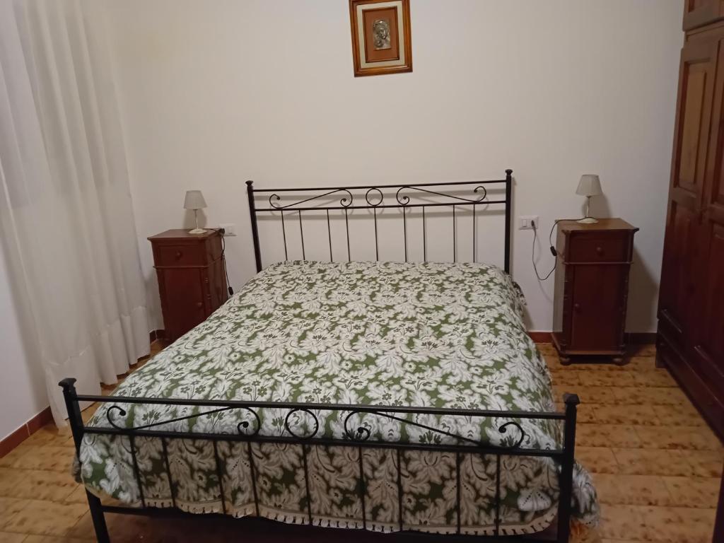 Casa Anna في Penna in Teverina: سرير في غرفة نوم مع مواقف ليلتين ومصباحين