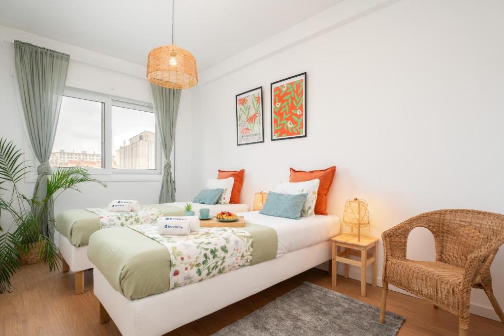 1 dormitorio con 2 camas y 1 silla en Spacious Modern Flat w/ Balcony, en Oporto