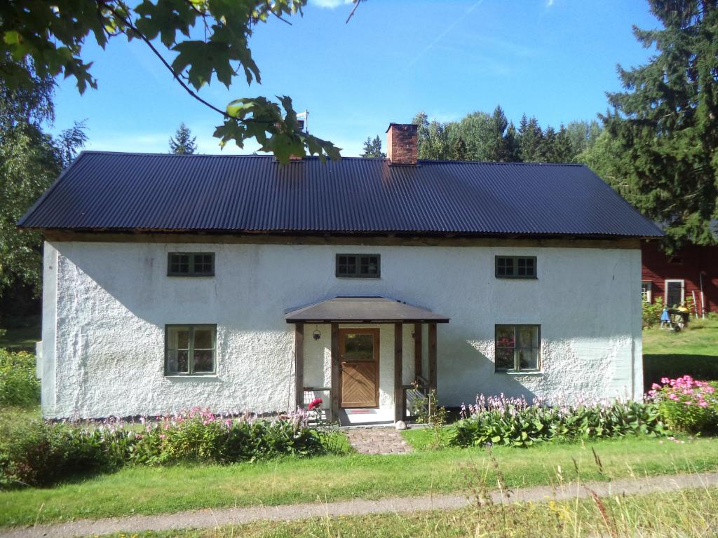 una casa blanca con techo negro en Kopparhyttan1 en Valdemarsvik