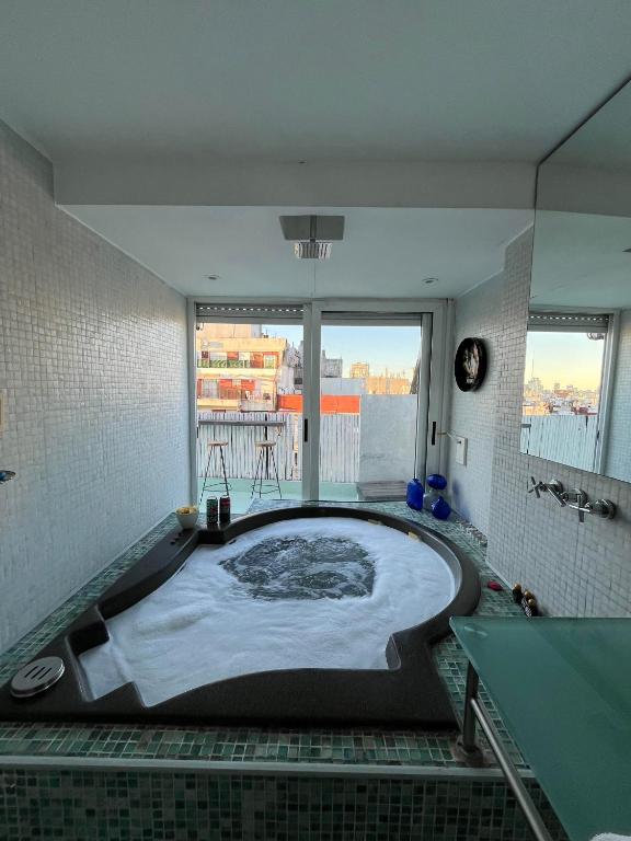 En eller flere senge i et værelse på Apart Recoleta con jacuzzi y balcón con parrilla propio
