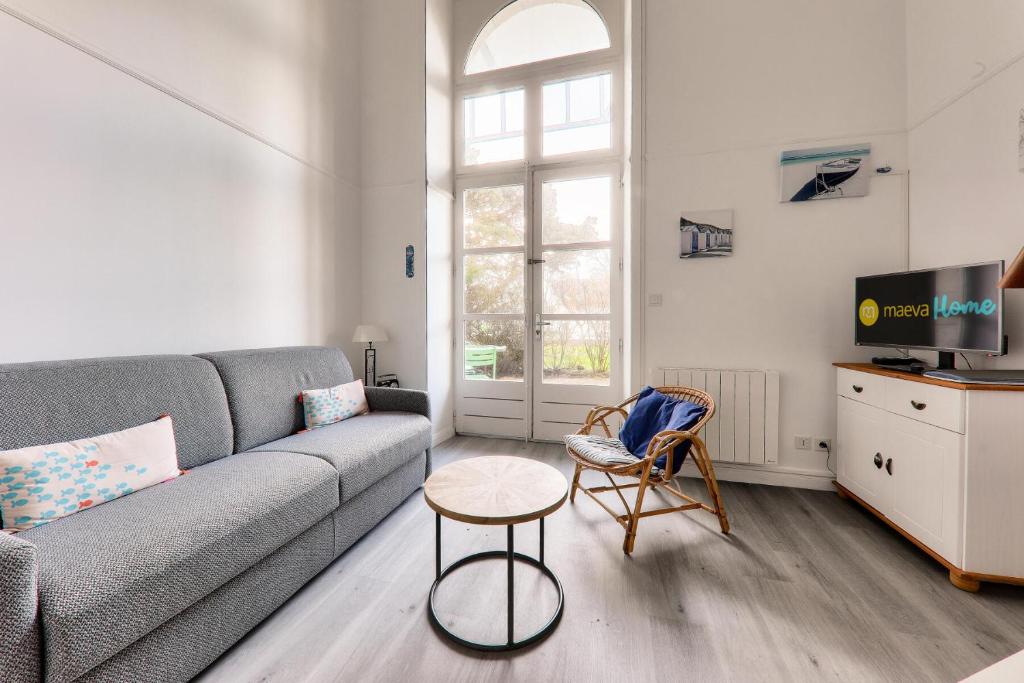 a living room with a couch and a tv at Résidence Saint Goustan - maeva Home - Studio 4 personnes - Prestige - maev 421 in Le Croisic